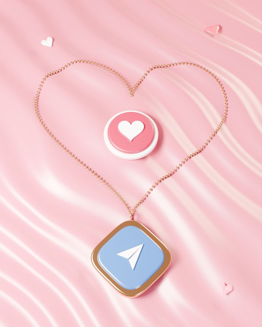A gold chain laid in a heart on rose satin, with ilysm's love you button inside and the paper plane charm hanging from its point